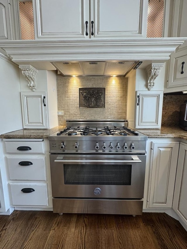 kitchen featuring white cabinets, backsplash, and stainless steel stove
