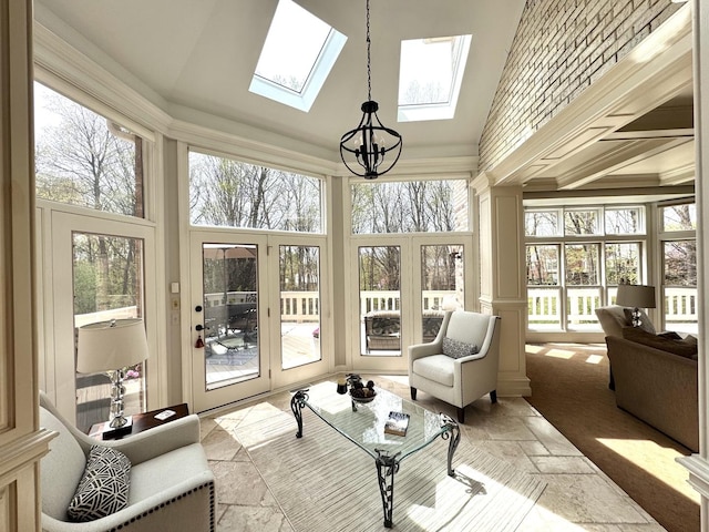 sunroom with french doors, a skylight, and an inviting chandelier