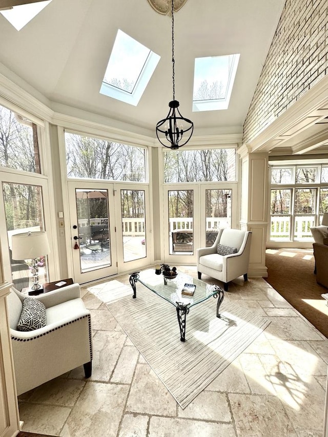 sunroom / solarium featuring an inviting chandelier, a skylight, and french doors