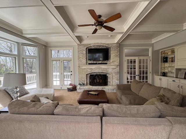 carpeted living area with coffered ceiling, ornamental molding, a ceiling fan, and french doors