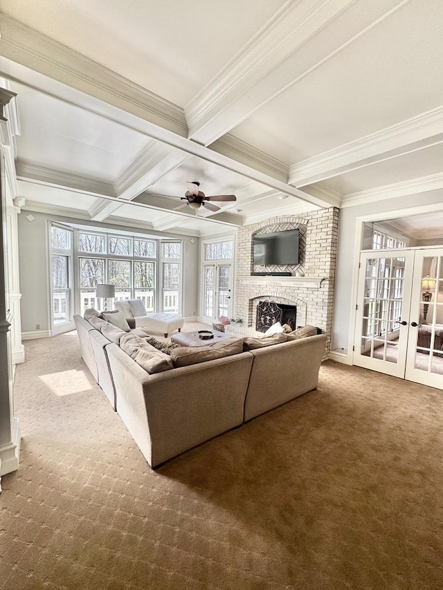 carpeted living room featuring french doors, ornamental molding, beam ceiling, and a fireplace