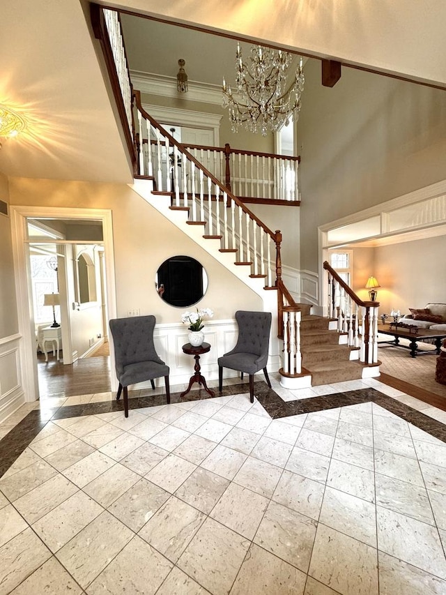 staircase featuring wainscoting, plenty of natural light, and a decorative wall