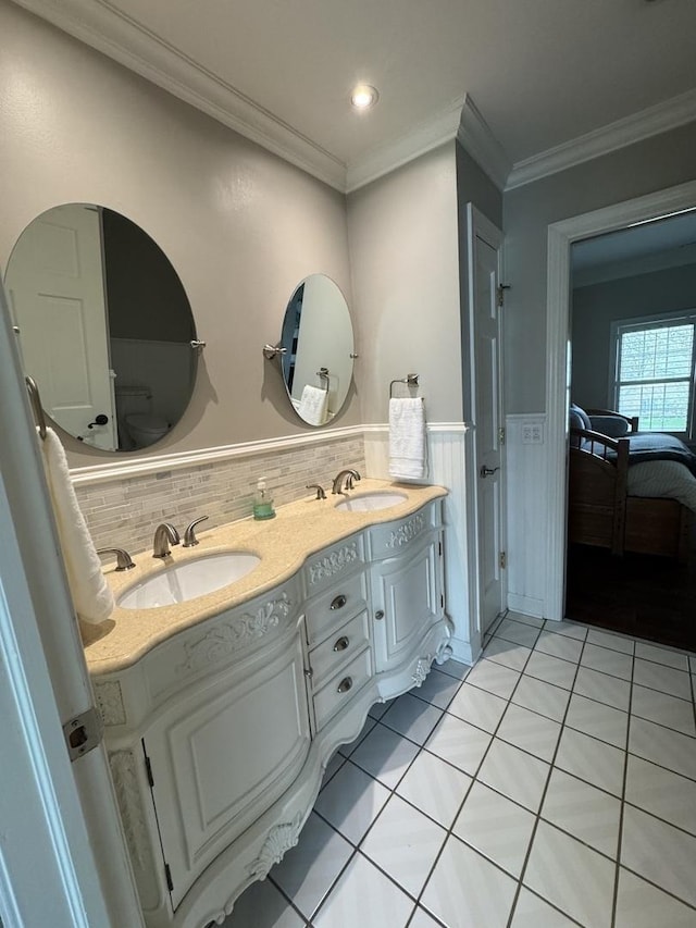 full bathroom featuring a sink, a wainscoted wall, tile patterned flooring, and double vanity