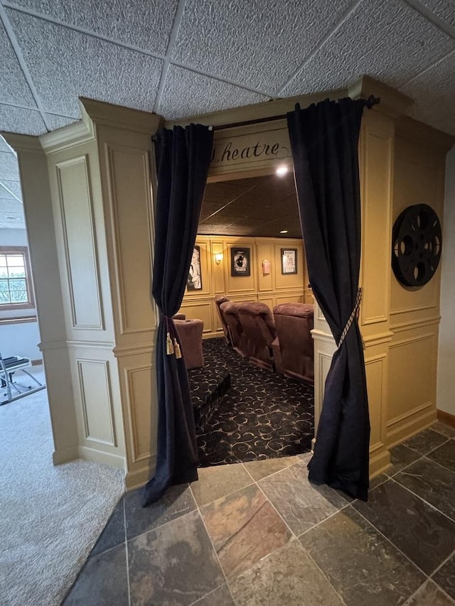 cinema featuring dark colored carpet and stone tile flooring
