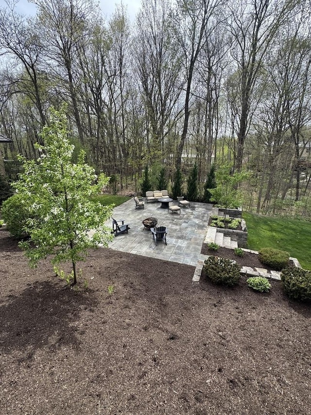 view of yard with an outdoor living space with a fire pit and a patio area