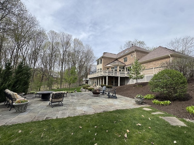exterior space with a patio, an outdoor fire pit, a wooden deck, and a yard