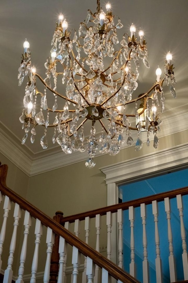 stairs featuring a notable chandelier and ornamental molding
