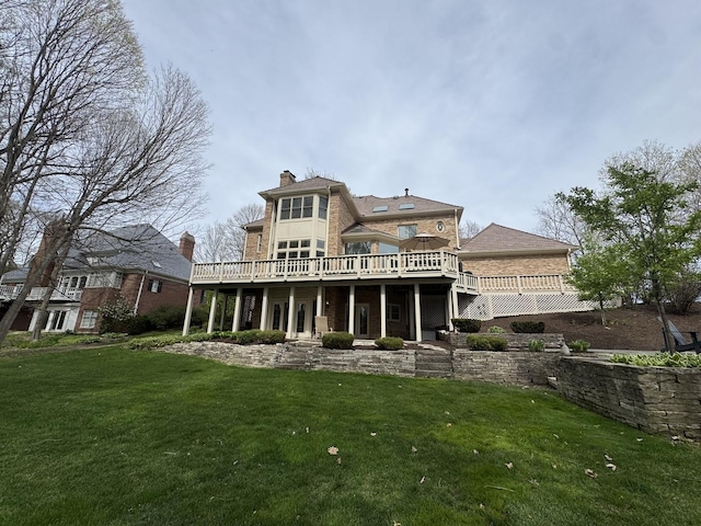 back of property featuring a lawn, a chimney, and a deck
