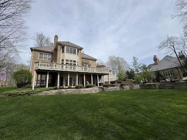 rear view of house featuring a chimney, a yard, and a deck