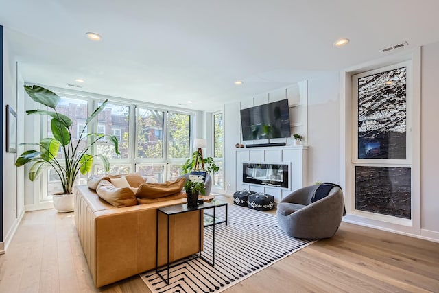 1462 W Winnemac Ave Unit 2, Chicago, IL 60640 - living room featuring recessed lighting, baseboards, a glass covered fireplace, visible vents, and light wood-type flooring