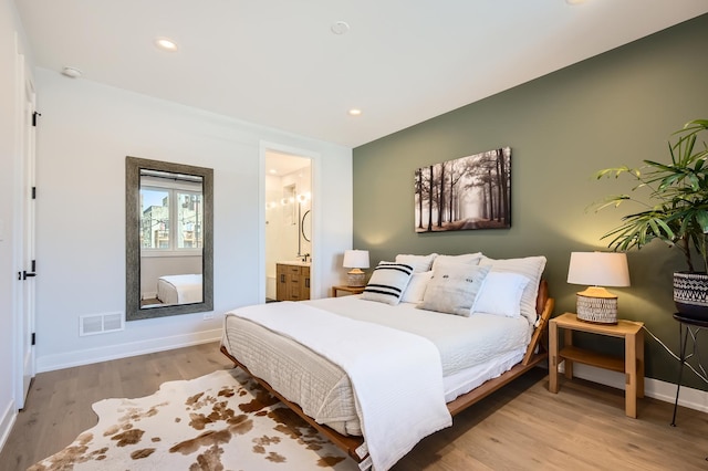 1462 W Winnemac Ave Unit 2, Chicago, IL 60640 - bedroom featuring wood finished floors, visible vents, baseboards, ensuite bath, and recessed lighting