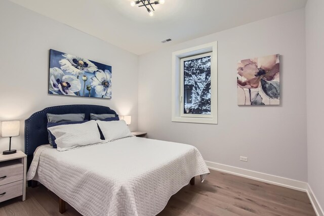 1462 W Winnemac Ave Unit 2, Chicago, IL 60640 - bedroom with baseboards, visible vents, and wood finished floors