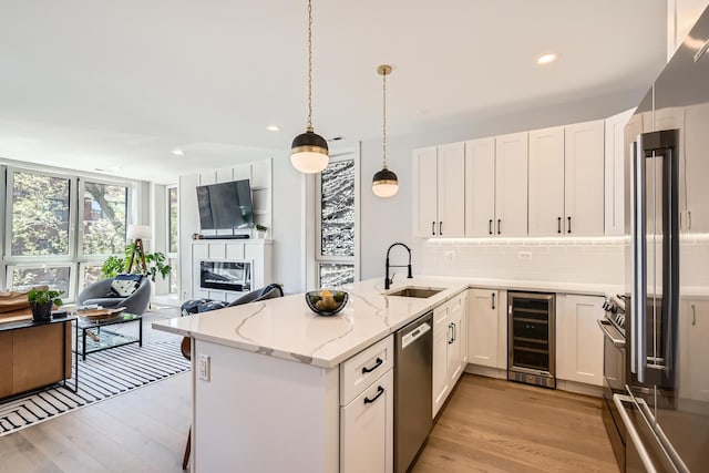 1462 W Winnemac Ave Unit 2, Chicago, IL 60640 - kitchen with a sink, stainless steel dishwasher, light wood-style floors, and beverage cooler