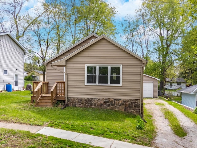 bungalow featuring a detached garage, an outbuilding, a front lawn, and dirt driveway