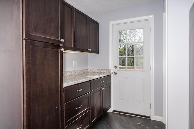 interior space featuring baseboards and dark wood-style floors