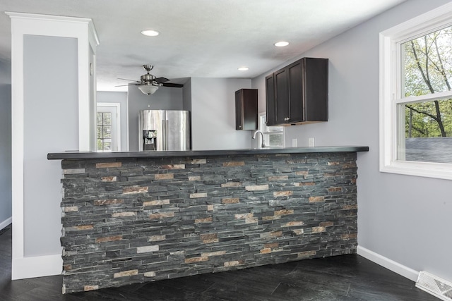 kitchen with dark brown cabinetry, visible vents, a wealth of natural light, and stainless steel fridge with ice dispenser