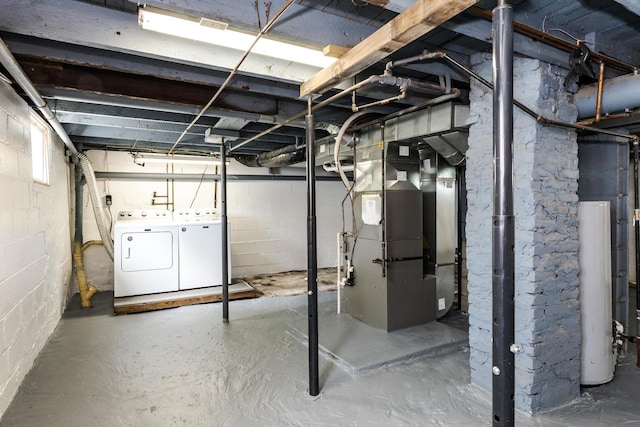 unfinished below grade area featuring water heater, heating unit, and independent washer and dryer