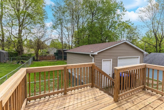 wooden deck with a fenced backyard, an outbuilding, a lawn, and a garage
