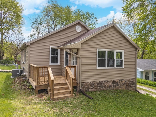 back of property with a lawn, cooling unit, and a wooden deck