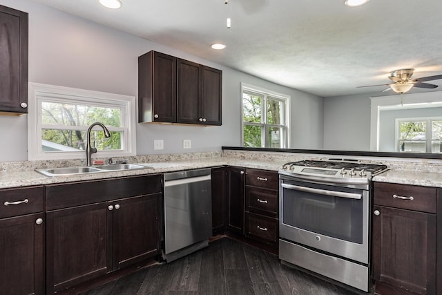 kitchen featuring dark brown cabinetry, ceiling fan, a sink, dark wood finished floors, and stainless steel appliances
