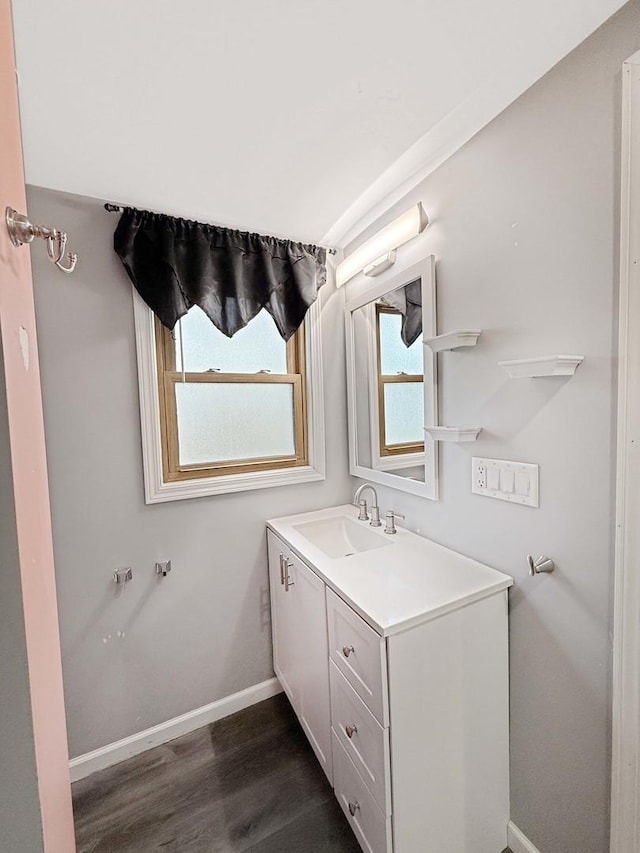 bathroom featuring wood finished floors, vanity, and baseboards