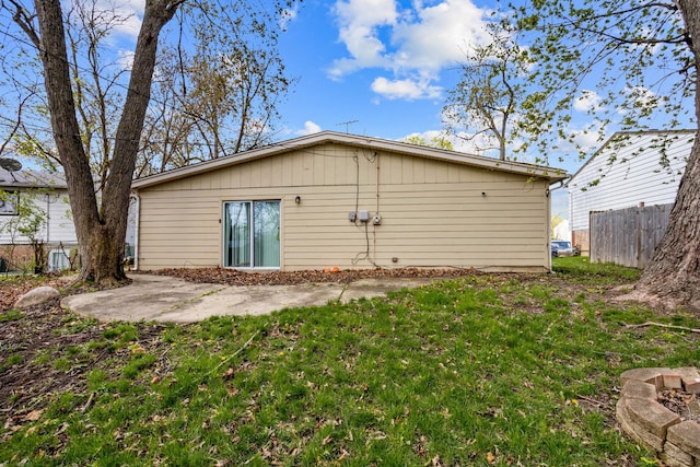 rear view of property with a yard, fence, and a patio area