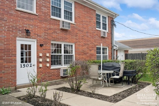 1502 Plymouth Pl Unit 1W, Glenview, IL 60025 - exterior space with fence, a wall unit AC, brick siding, and a patio
