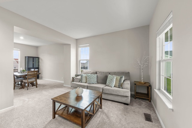 carpeted living room with baseboards and visible vents