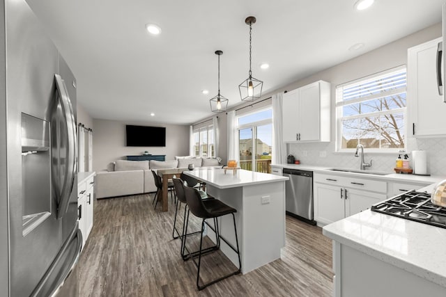 kitchen with a healthy amount of sunlight, open floor plan, stainless steel appliances, and a sink