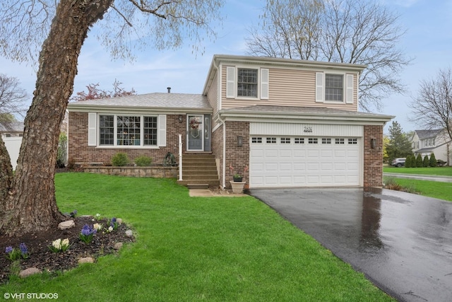 tri-level home featuring an attached garage, a front yard, driveway, and brick siding