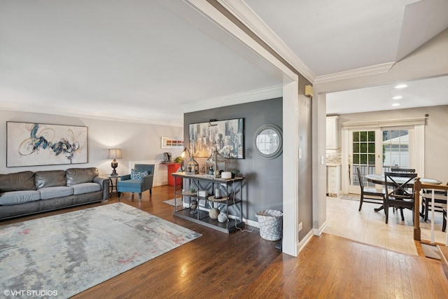 living room with crown molding, baseboards, and wood finished floors