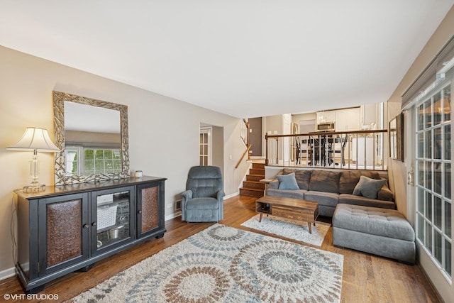 living room with stairs, baseboards, and wood finished floors