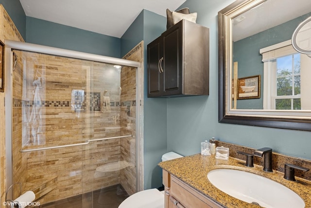 full bathroom featuring vanity, a stall shower, and toilet