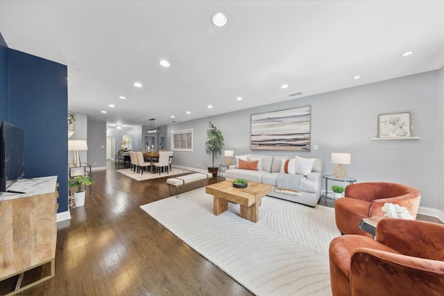 living room with dark wood-style flooring, visible vents, baseboards, and recessed lighting