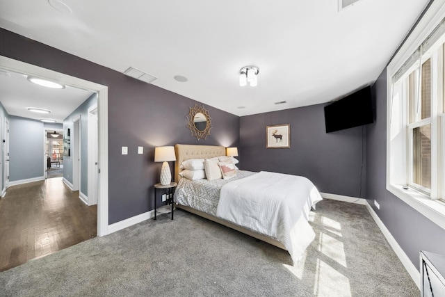 carpeted bedroom with visible vents and baseboards