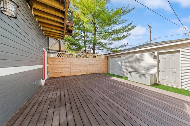 wooden terrace featuring fence and an outdoor structure