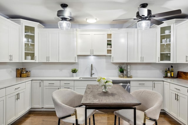 kitchen with a sink, dishwasher, white cabinetry, and light countertops