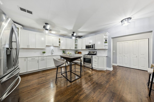 kitchen with visible vents, white cabinetry, open shelves, light countertops, and appliances with stainless steel finishes