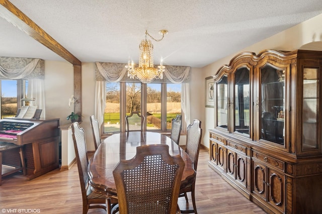 12524 Grandview Dr, Huntley, IL 60142 - dining area with a chandelier, a textured ceiling, light wood finished floors, and baseboards