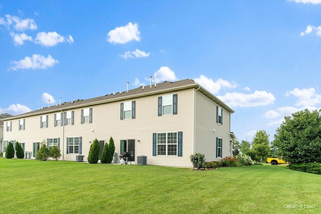 rear view of property with a yard and central AC unit