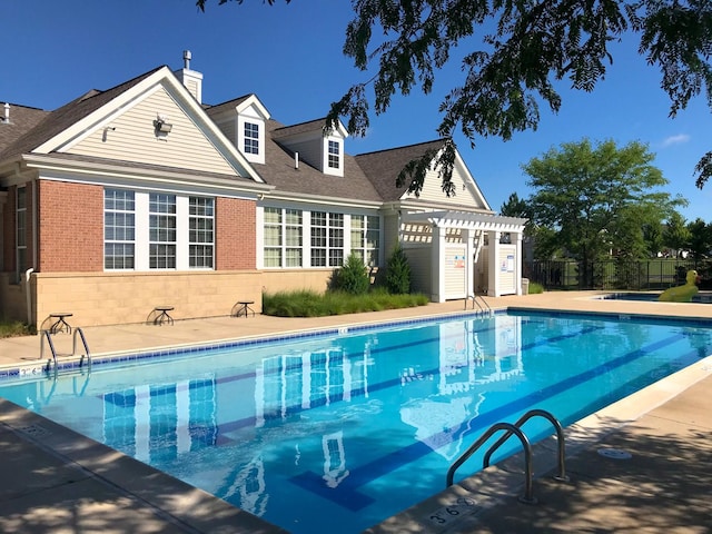 community pool featuring a pergola, fence, and a patio