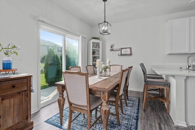 dining space with light wood finished floors, baseboards, and an inviting chandelier