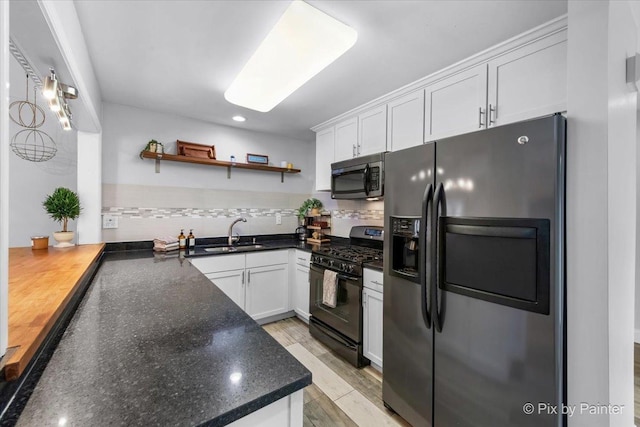 kitchen featuring open shelves, stainless steel appliances, a sink, and white cabinetry