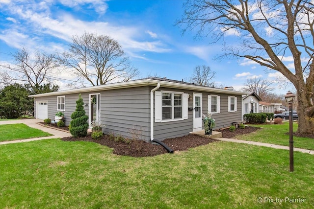 view of front of house featuring an attached garage, driveway, and a front lawn
