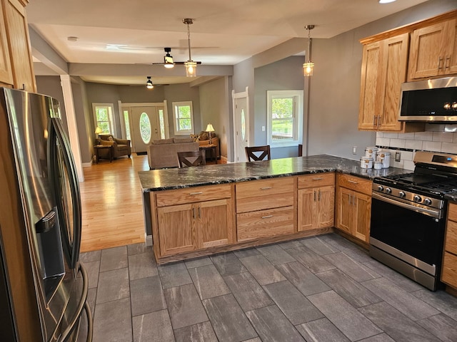 kitchen featuring stainless steel appliances, a peninsula, decorative backsplash, open floor plan, and pendant lighting