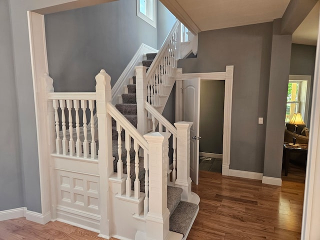 stairs with wood finished floors and baseboards