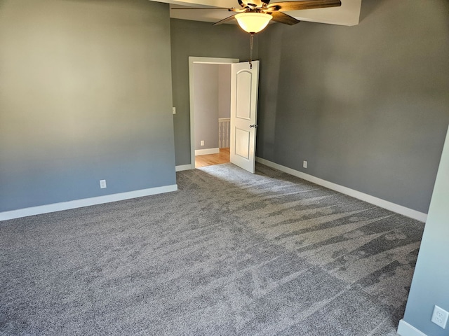 carpeted empty room with ceiling fan and baseboards