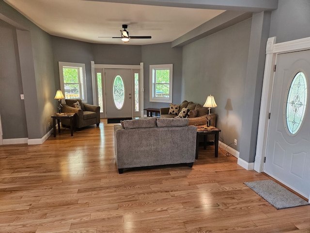 living room featuring healthy amount of natural light, a ceiling fan, light wood-type flooring, and baseboards