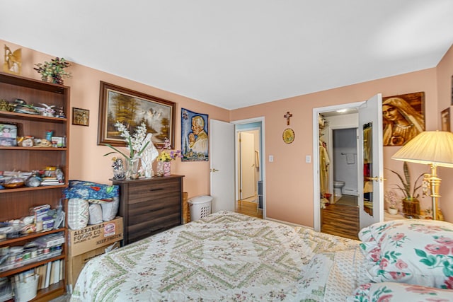 bedroom with a baseboard heating unit and wood finished floors