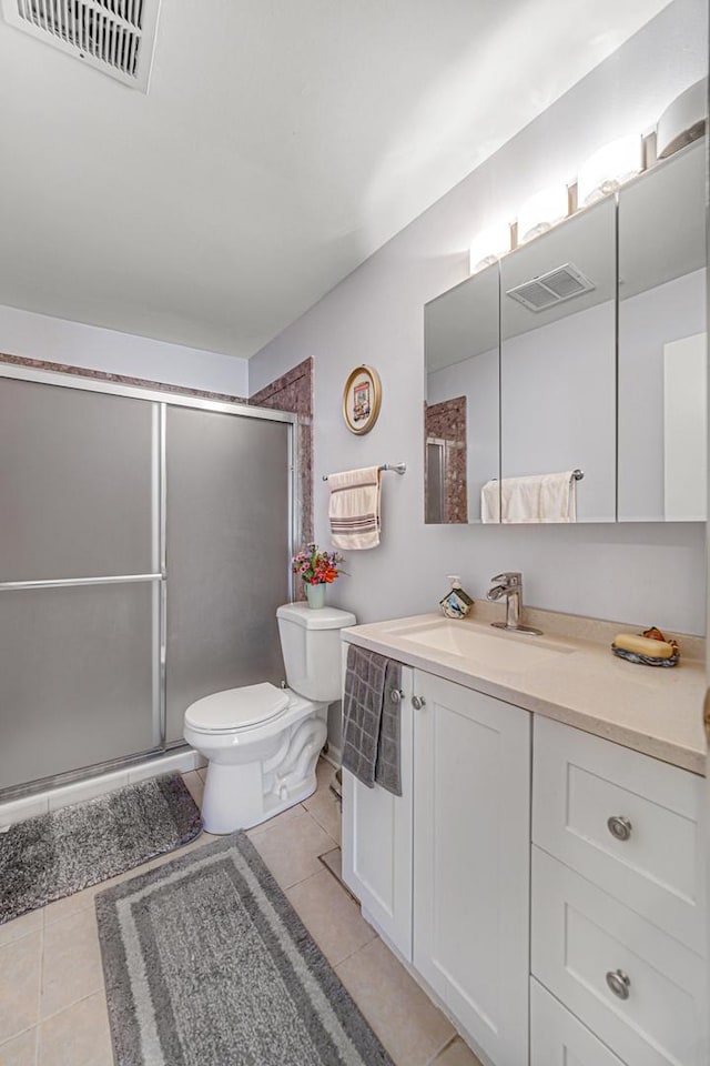bathroom featuring toilet, visible vents, and a stall shower